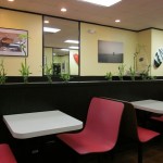 The dining area is decorated with surfboards, bamboo plants and framed photos.